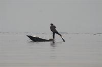 Fisherman paddling with his leg